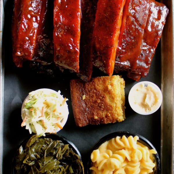 Fat Pete's BBQ ribs, cornbread, coleslaw, collard greens, mac and cheese, and butter.